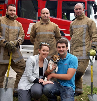Jake the Jack Russell happy in the arms of owners Steffan Williams and Katie Spence after being rescued by fiefighters, left to right Tim Davidson, James Lewis and Ian Ramshaw 