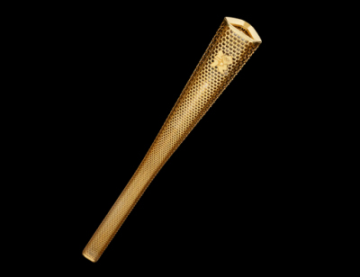 The Torch's triangular, gold-coloured form is perforated by 8,000 circles representing the 8,000 Torchbearers and their stories of personal achievement and/or contribution to their local community which will be celebrated during the London 2012 Olympic Torch Relay