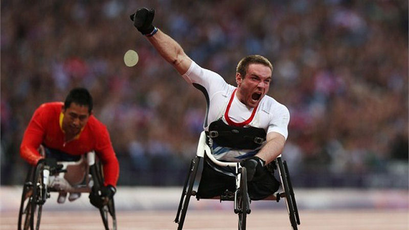 Mickey Bushell crosses the line to win gold in the men's 100m - T53 final. Mickey Bushell crosses the line to win gold in the men's 100m - T53 final.