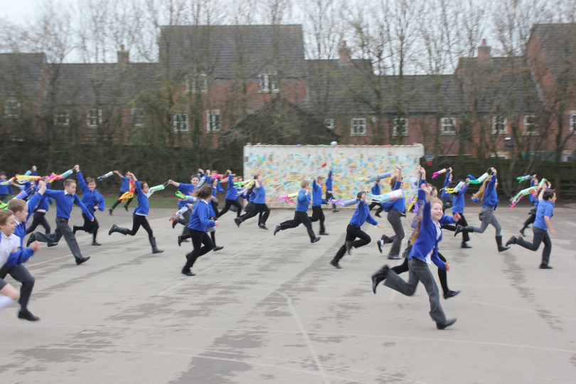 Children engaging with their artwork by running through the school grounds to ‘capture’ the wind
