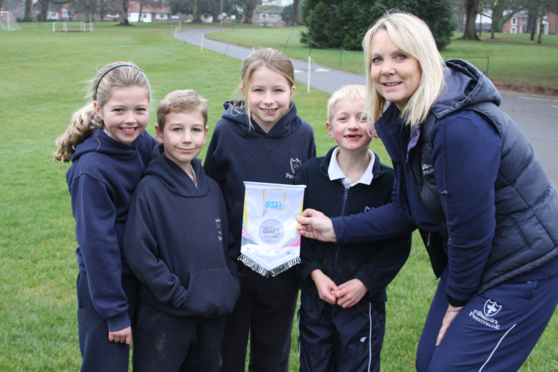 Tina Owen, head of girls games at Prestfelde, with pupils and the award