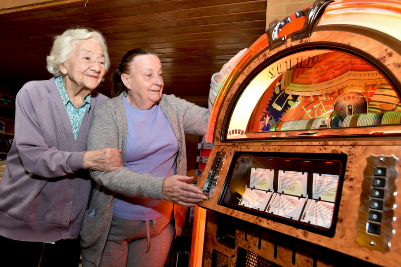 Enid Verdmore and Margaret Richardson enjoy listening to a jukebox at Innage Grange