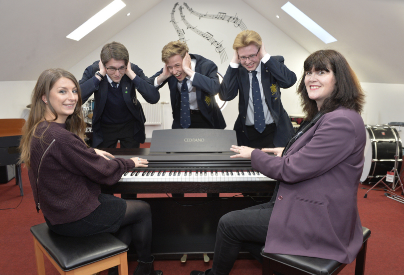 From left, pupils Daniel Cubbon, Jonty Watt and James Sale, listening to Sonya Bagley try out the school’s current piano with parent fundraiser Caroline Haves