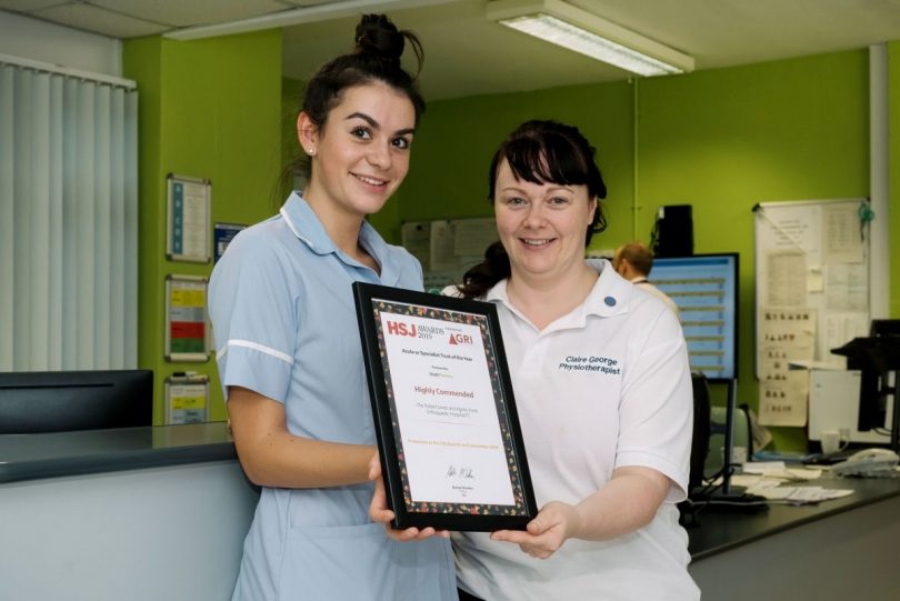 Pictured with the award certificate are Aimee Guilar, Staff Nurse on Kenyon Ward; and Claire George, Physiotherapist