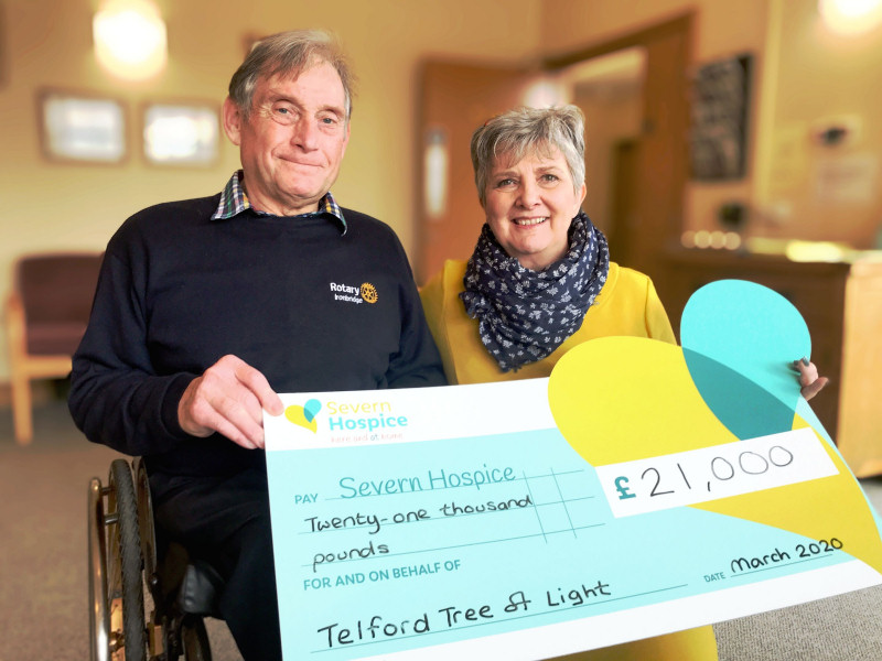 Rotarian Max Clowes, chair of the Telford Tree of Light organising committee hands a cheque to Norma Ross, Severn Hospice director of income generation