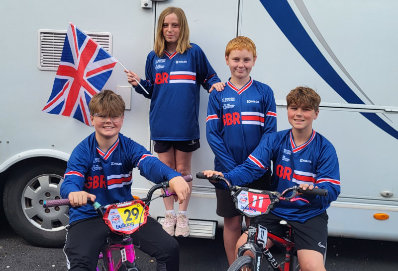 Eddie and Archie Smallman on bikes; Alex Hemmings (middle) and Sophie Kynaston (back holding flag)
