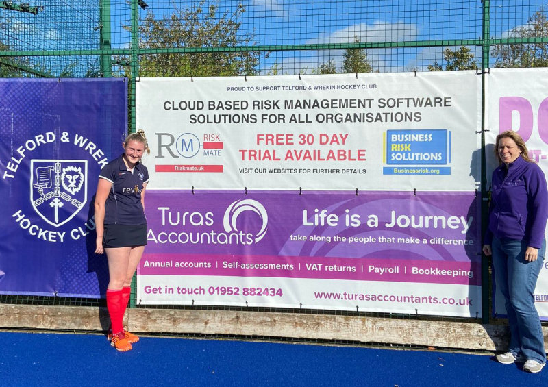 Lucy Jones-Columb and Helen Columb with the hockey club banner