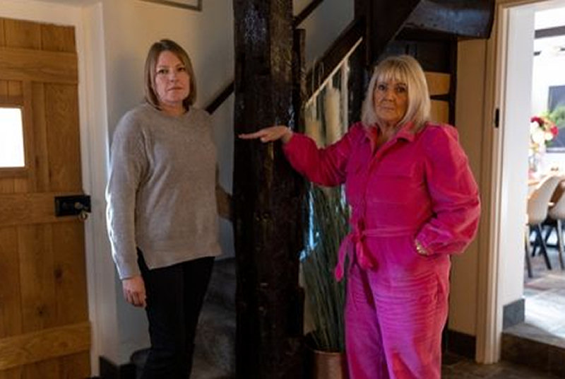 Councillor Carolyn Healy pictured with Coalbrookdale resident Beverley Flynn, pointing out the height flood water reached in 2020 inside her home. Photo: Telford & Wrekin Council