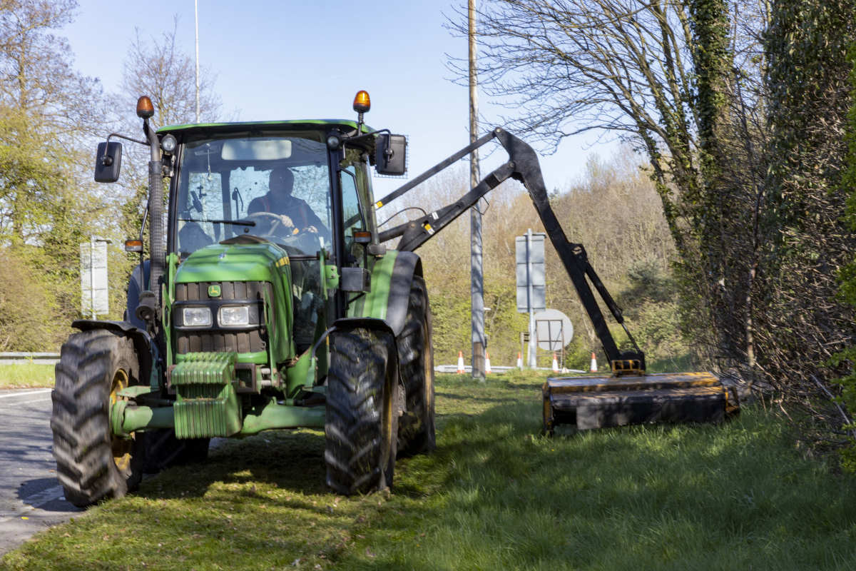 Grass cutting takes place along a verge in Telford