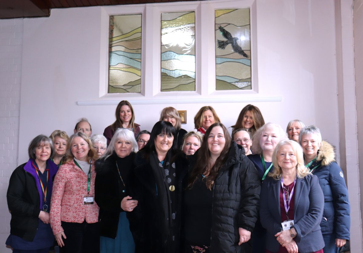 Members of ECPS, as well as Catherine Wignall, Anne Wignall and EC Headmaster Vicky Pritt Roberts by the stained glass window in memory of Brendan Wignall